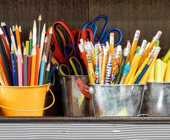 Small desk buckets filled with school supplies