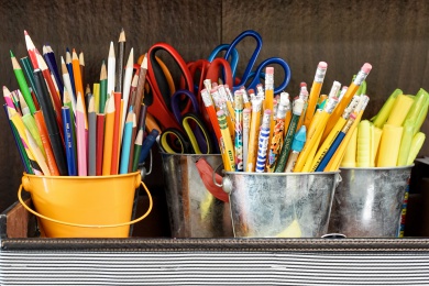 Small desk buckets filled with school supplies